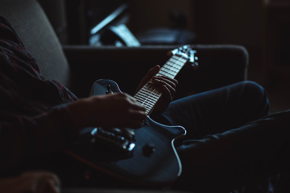 Foto in scala di grigi di una persona che suona la chitarra elettrica