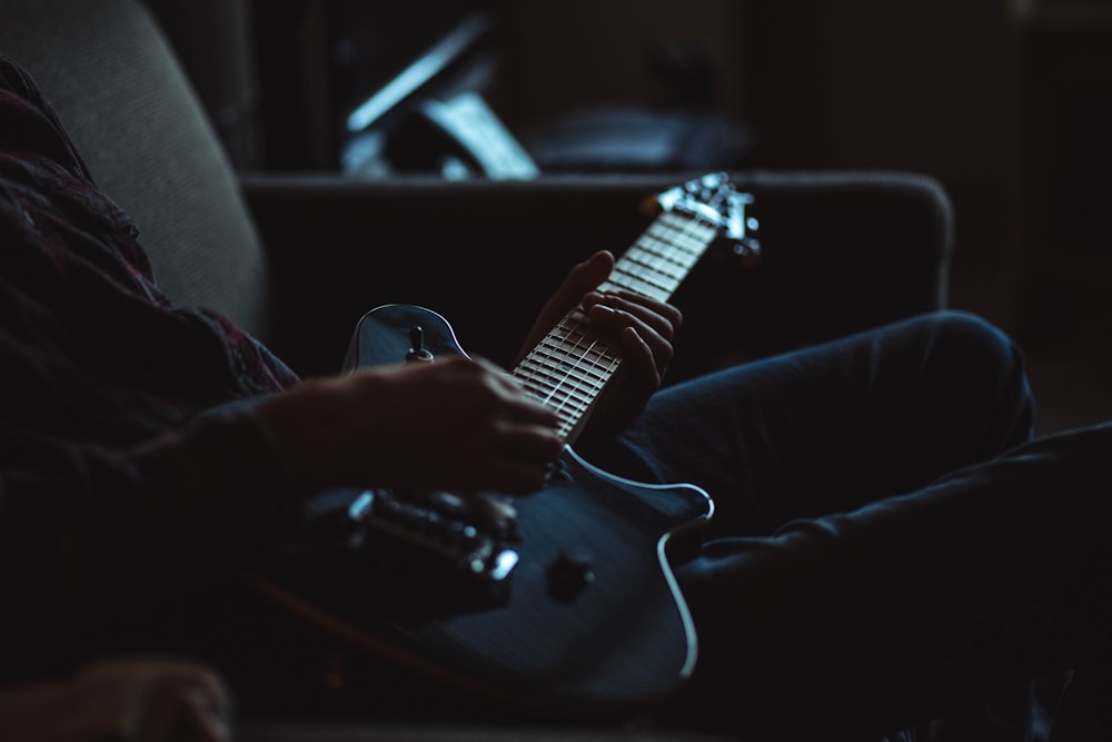 grayscale photo of person playing electric guitar