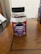 A plastic bottle of Multilife Vitamins featuring elderberry and vitamin C gummies with zinc is placed on a wooden surface. The label prominently displays images of elderberries and citrus fruits with the text indicating 60 gummies per bottle. The overall setting appears to be indoors, likely on a table or desk.