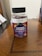 A plastic bottle of Multilife Vitamins featuring elderberry and vitamin C gummies with zinc is placed on a wooden surface. The label prominently displays images of elderberries and citrus fruits with the text indicating 60 gummies per bottle. The overall setting appears to be indoors, likely on a table or desk.