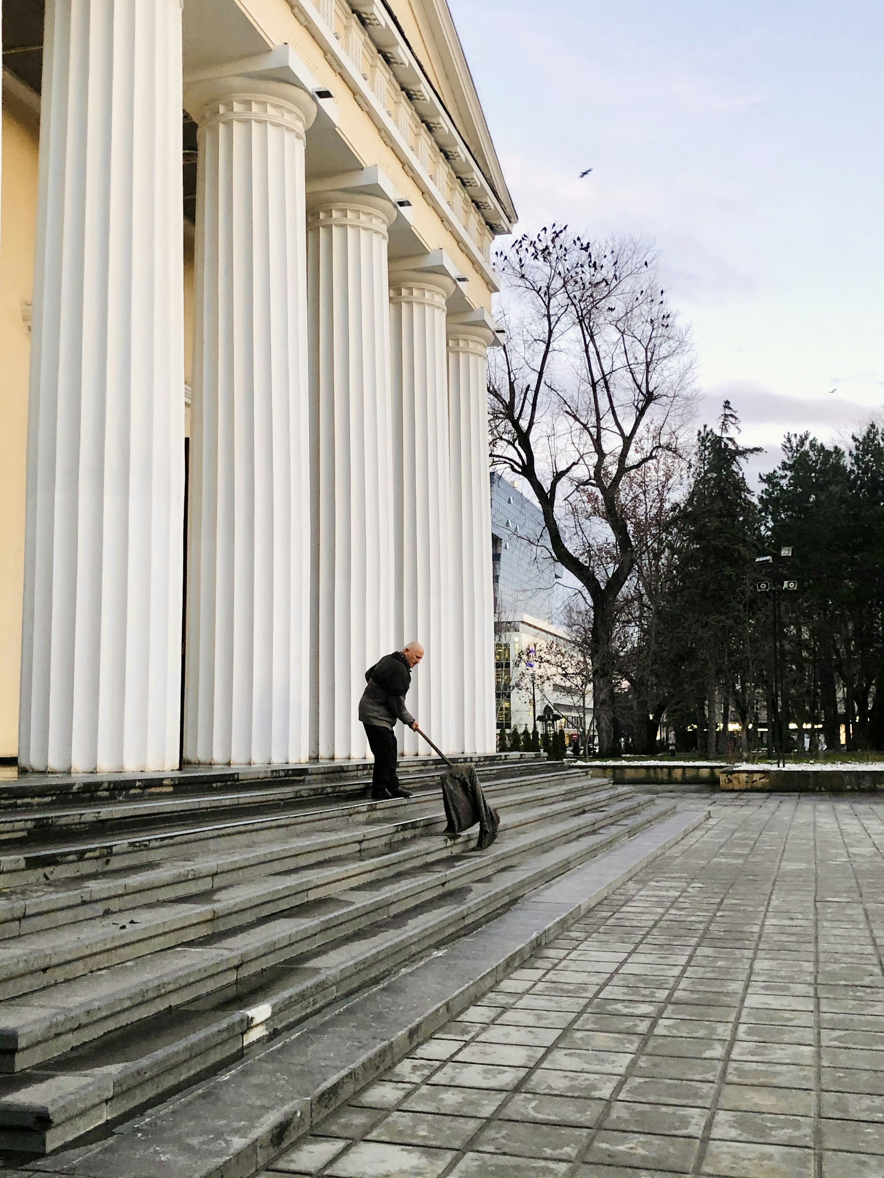 man in black jacket and black pants walking on sidewalk during daytime