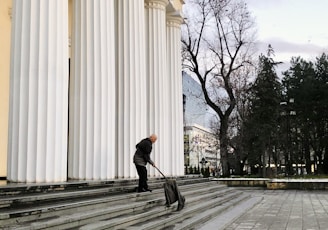 man in black jacket and black pants walking on sidewalk during daytime