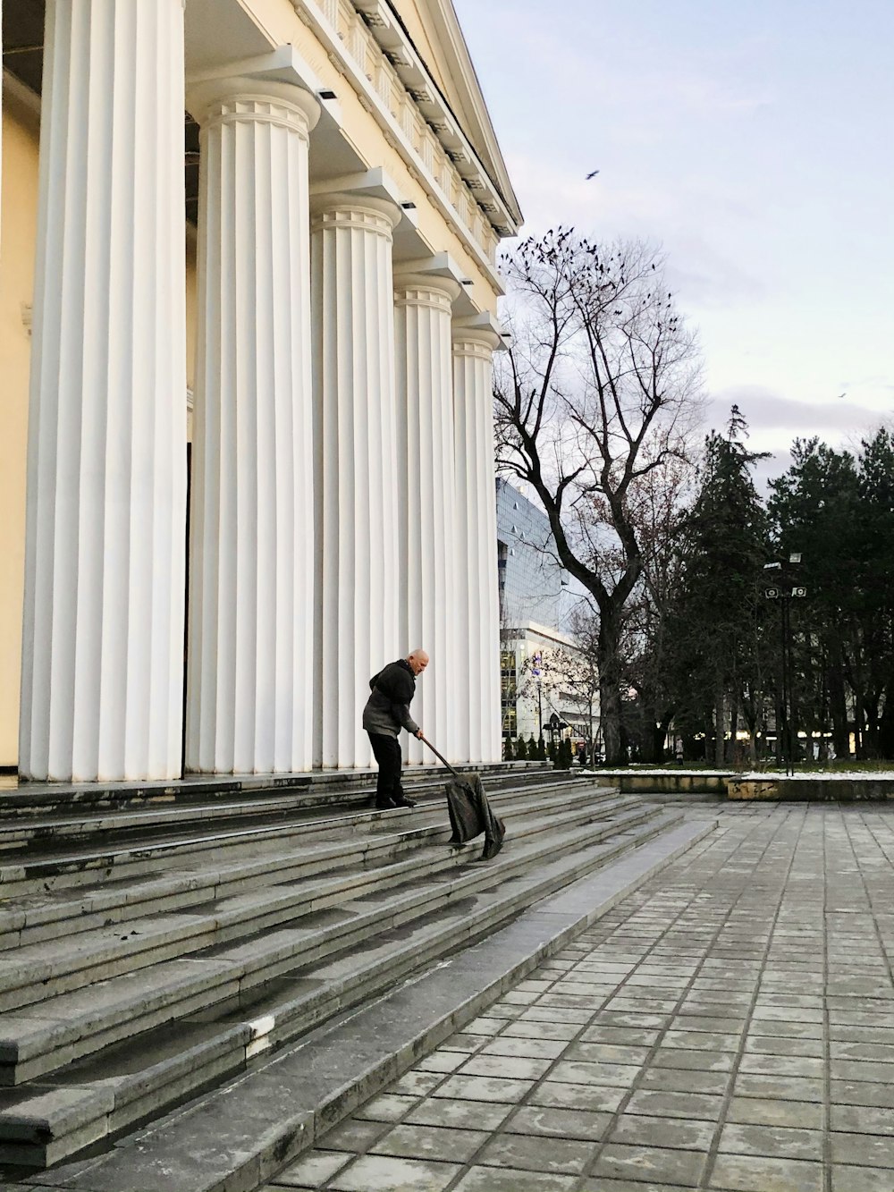 man in black jacket and black pants walking on sidewalk during daytime