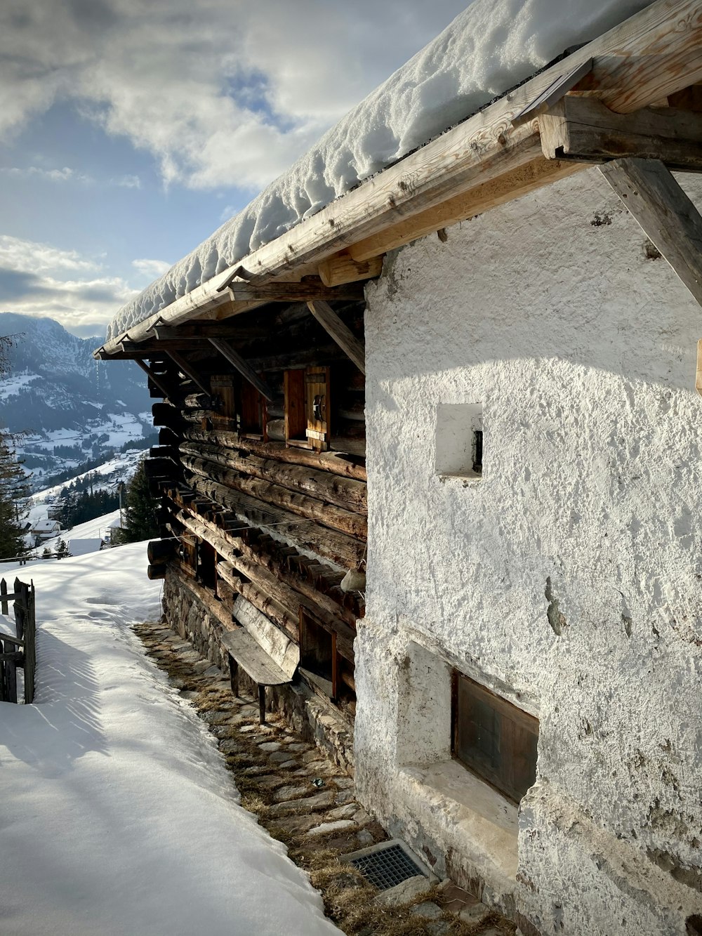 Una casa coperta di neve con una montagna sullo sfondo