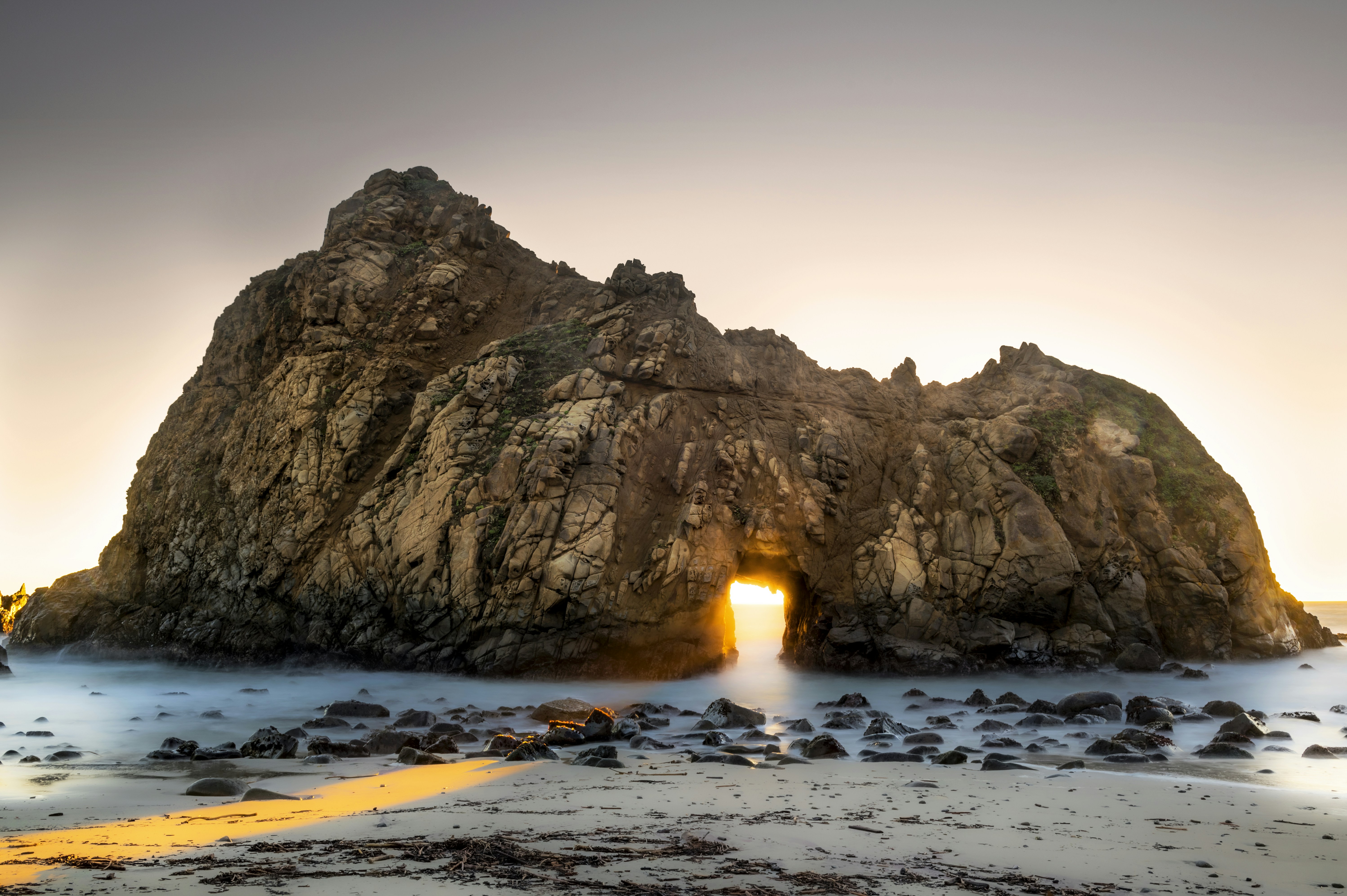 brown rock formation on sea shore during daytime, Keyhole Arch during Sunset