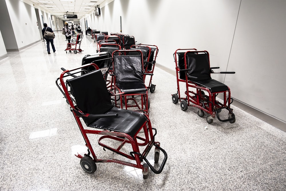 a row of red and black chairs in a hallway