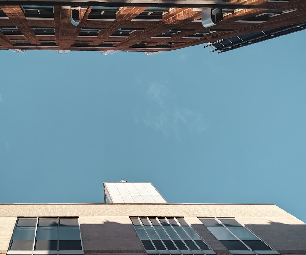 bâtiment en béton blanc et brun sous le ciel bleu pendant la journée