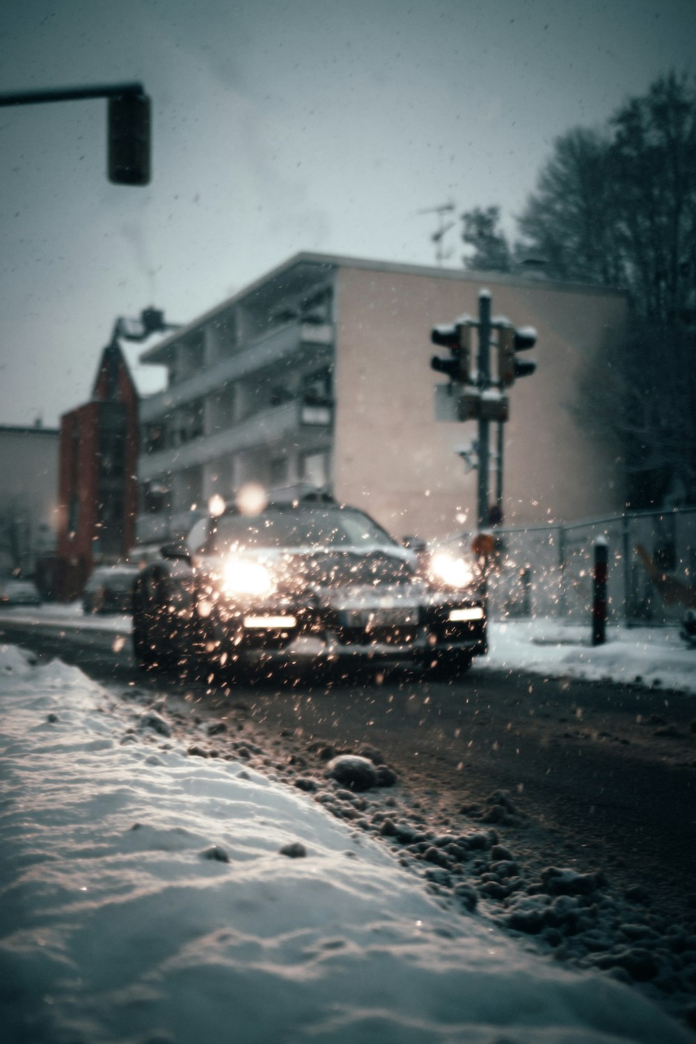 auto nera su strada coperta di neve durante il giorno
