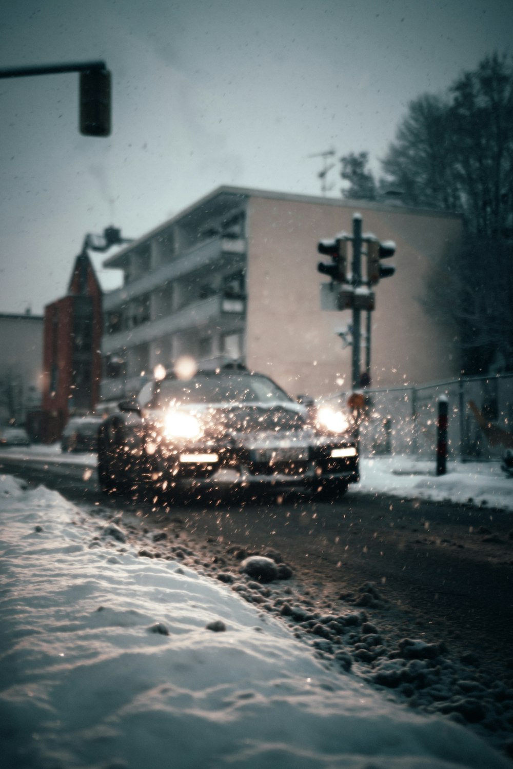 black car on road covered with snow during daytime