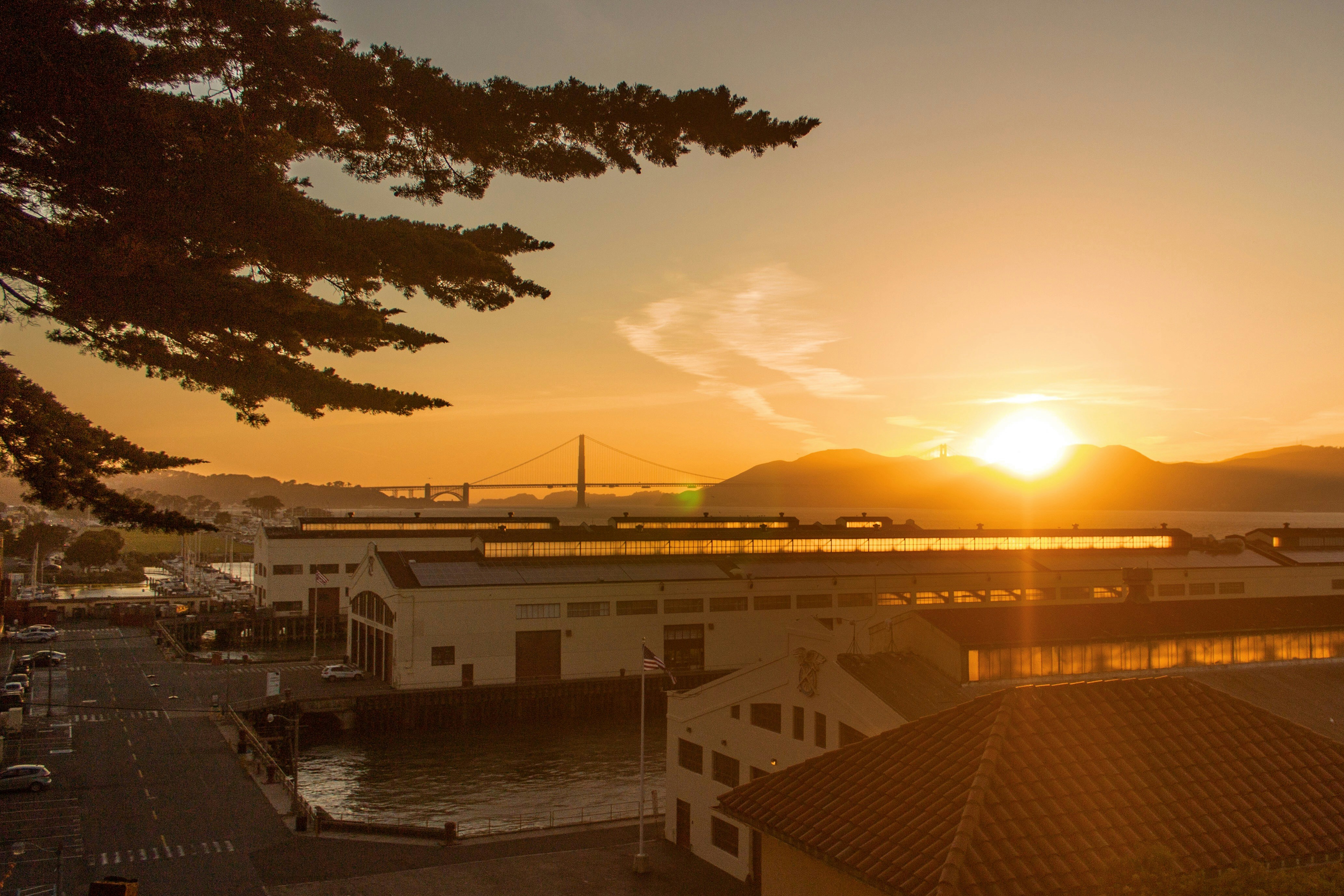 Bâtiment en béton blanc et brun près d’un plan d’eau au coucher du soleil