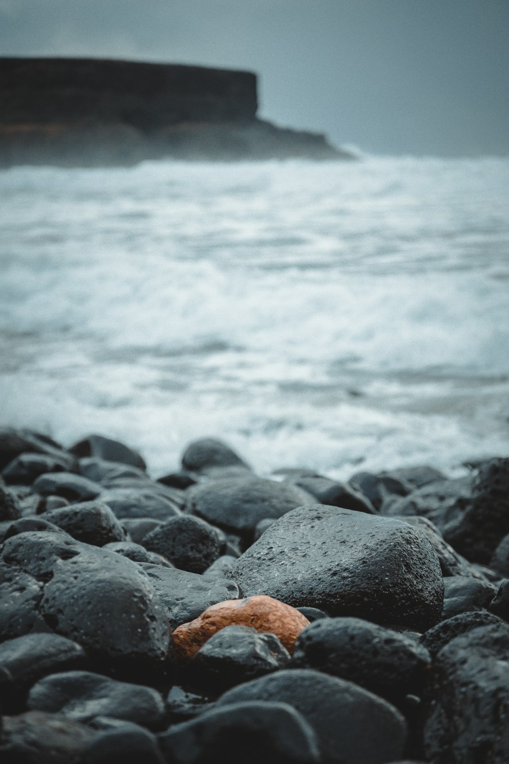 brown and black stones near body of water during daytime