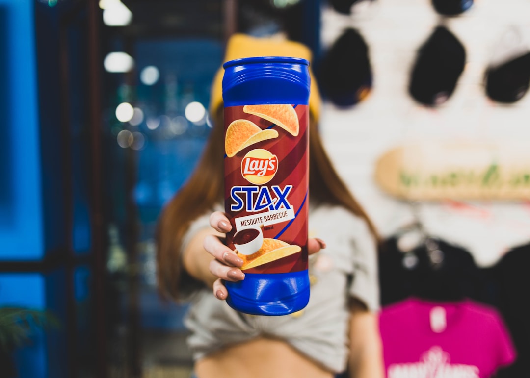 person holding orange and blue plastic bottle