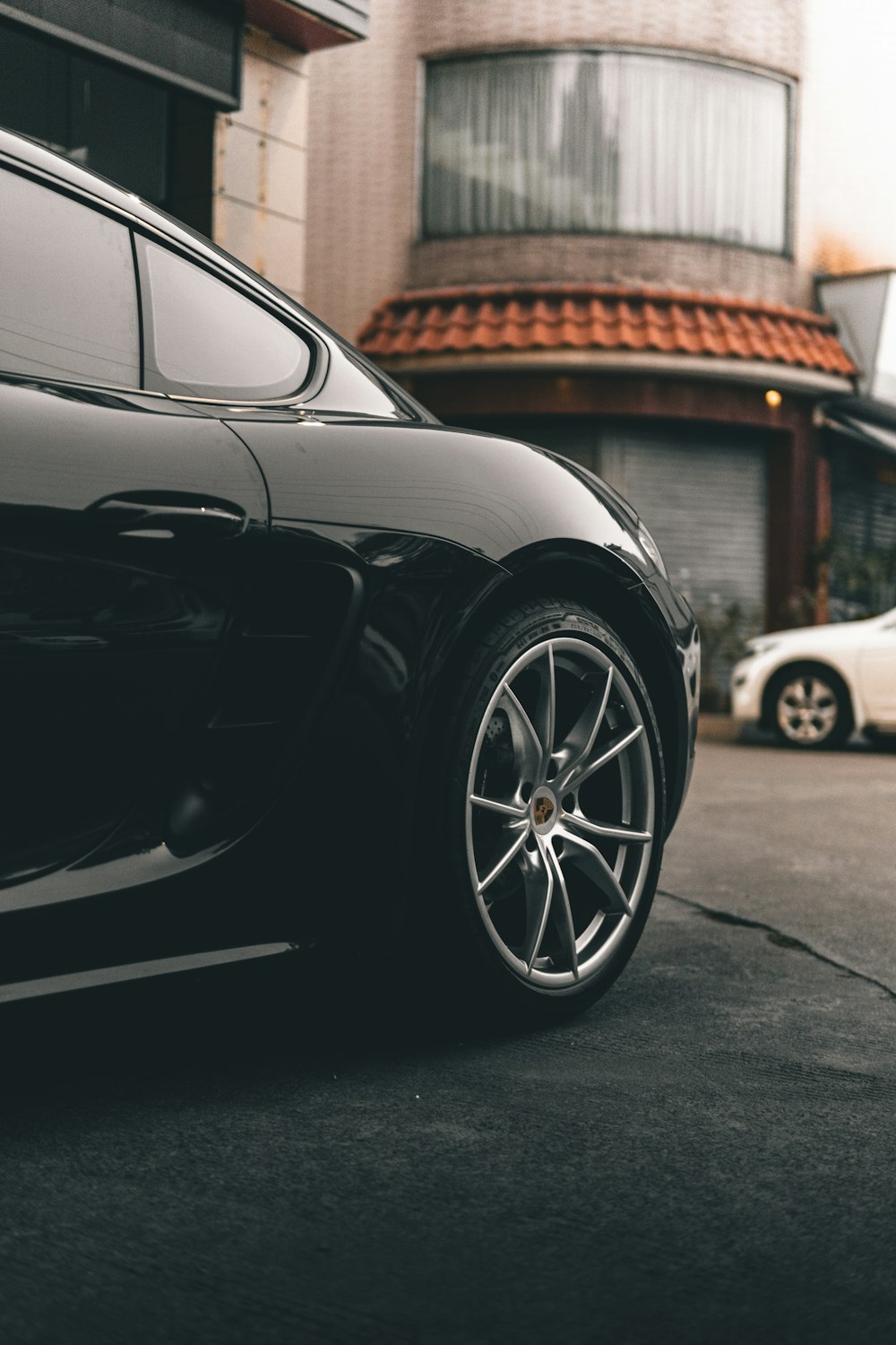 black car parked near brown building during daytime