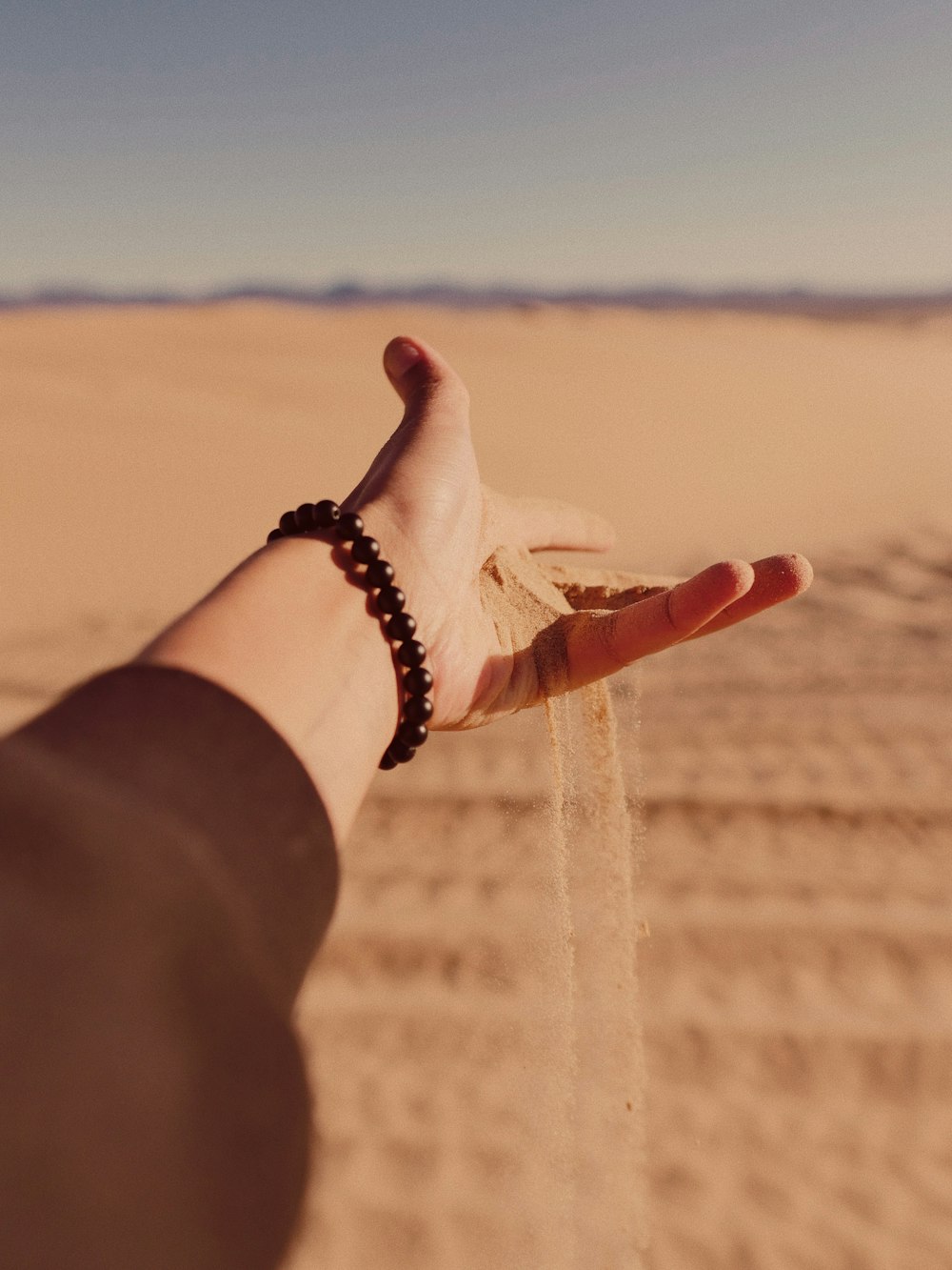 person wearing black leather bracelet