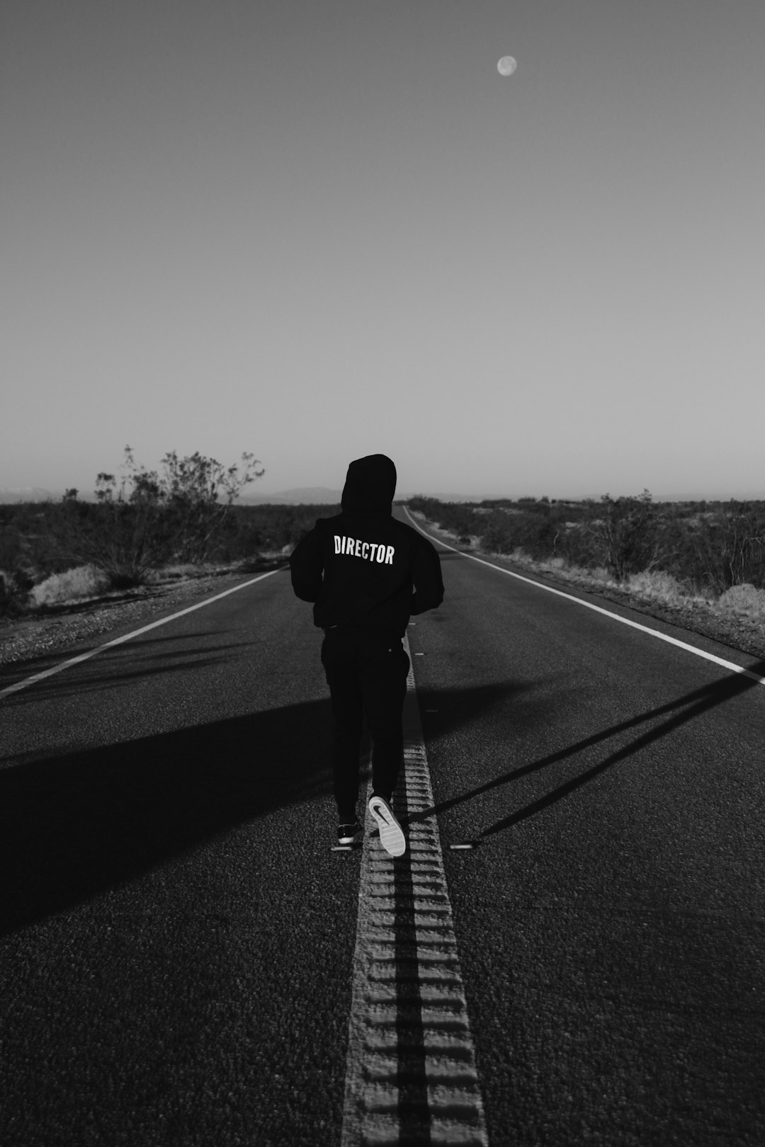 man in black jacket and black pants walking on the road