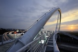 Engineers inspecting a modern bridge structure during sunset.