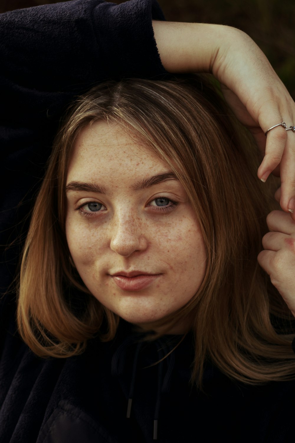 woman with brown hair holding her hair