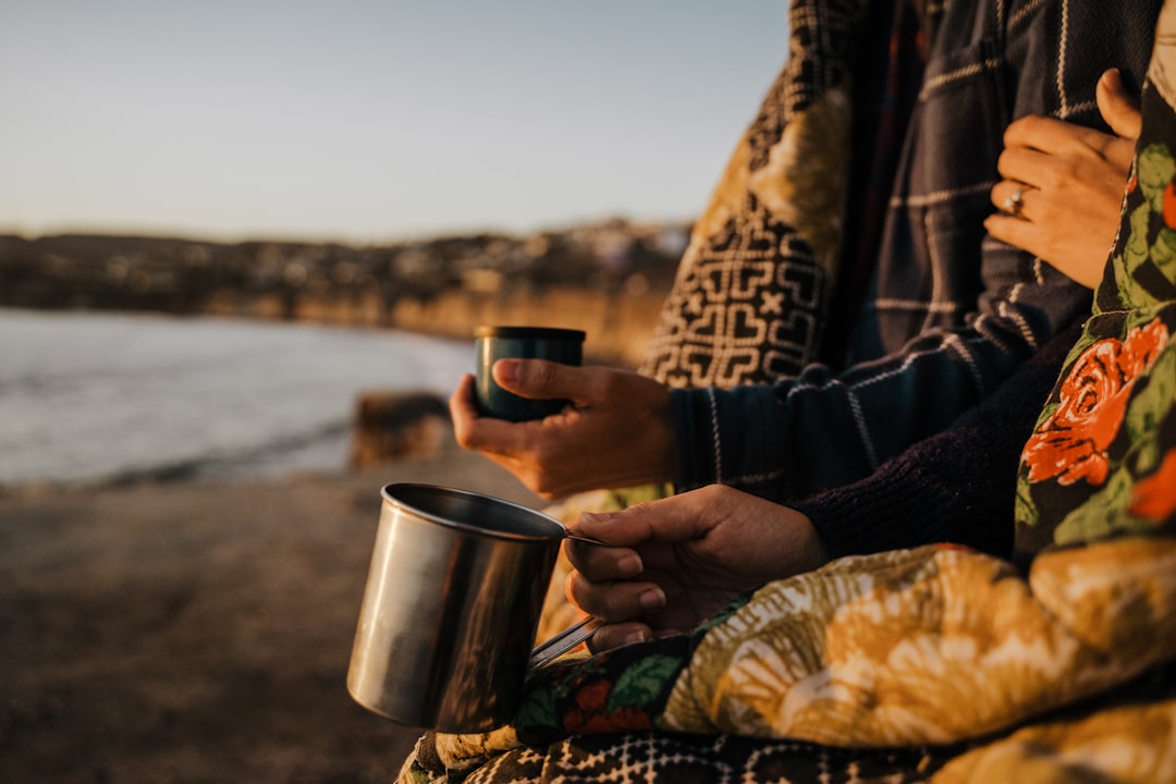 person holding stainless steel cup