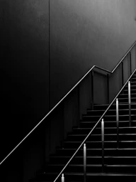 grayscale photo of staircase with railings