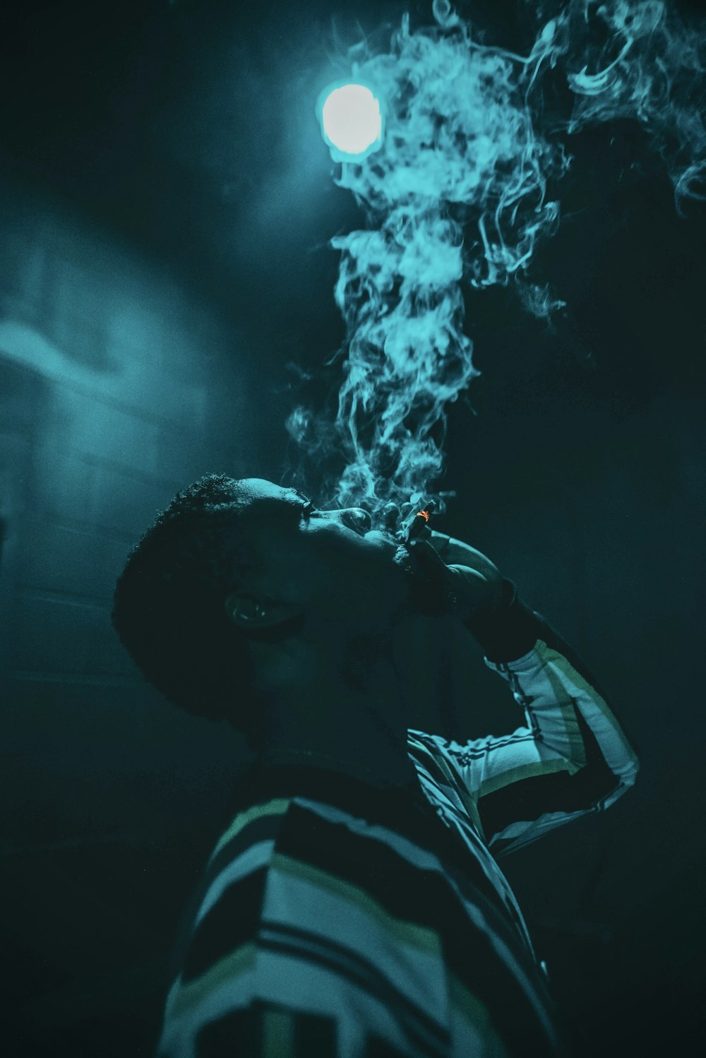 man in black and white striped shirt smoking