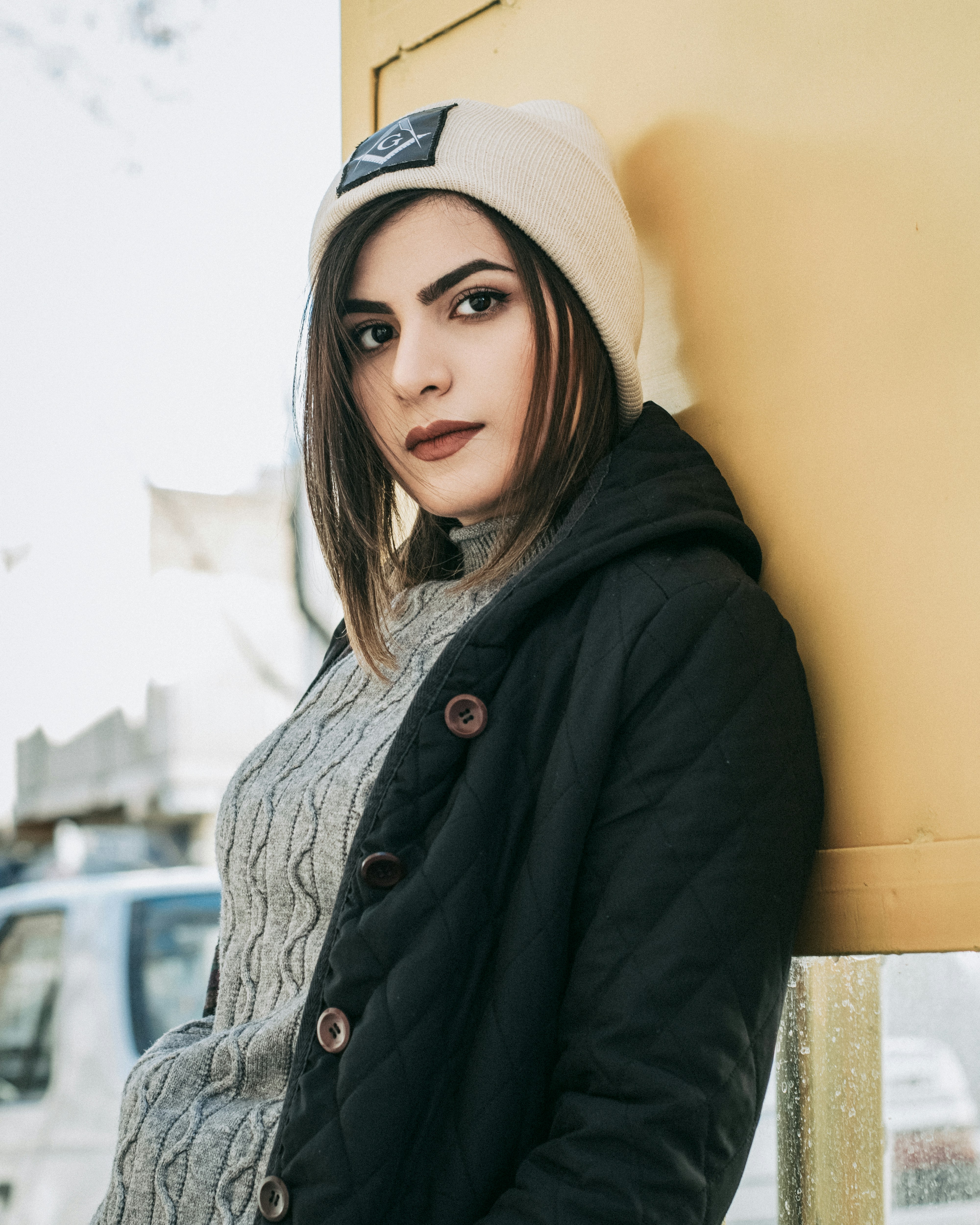 woman in black jacket wearing white knit cap