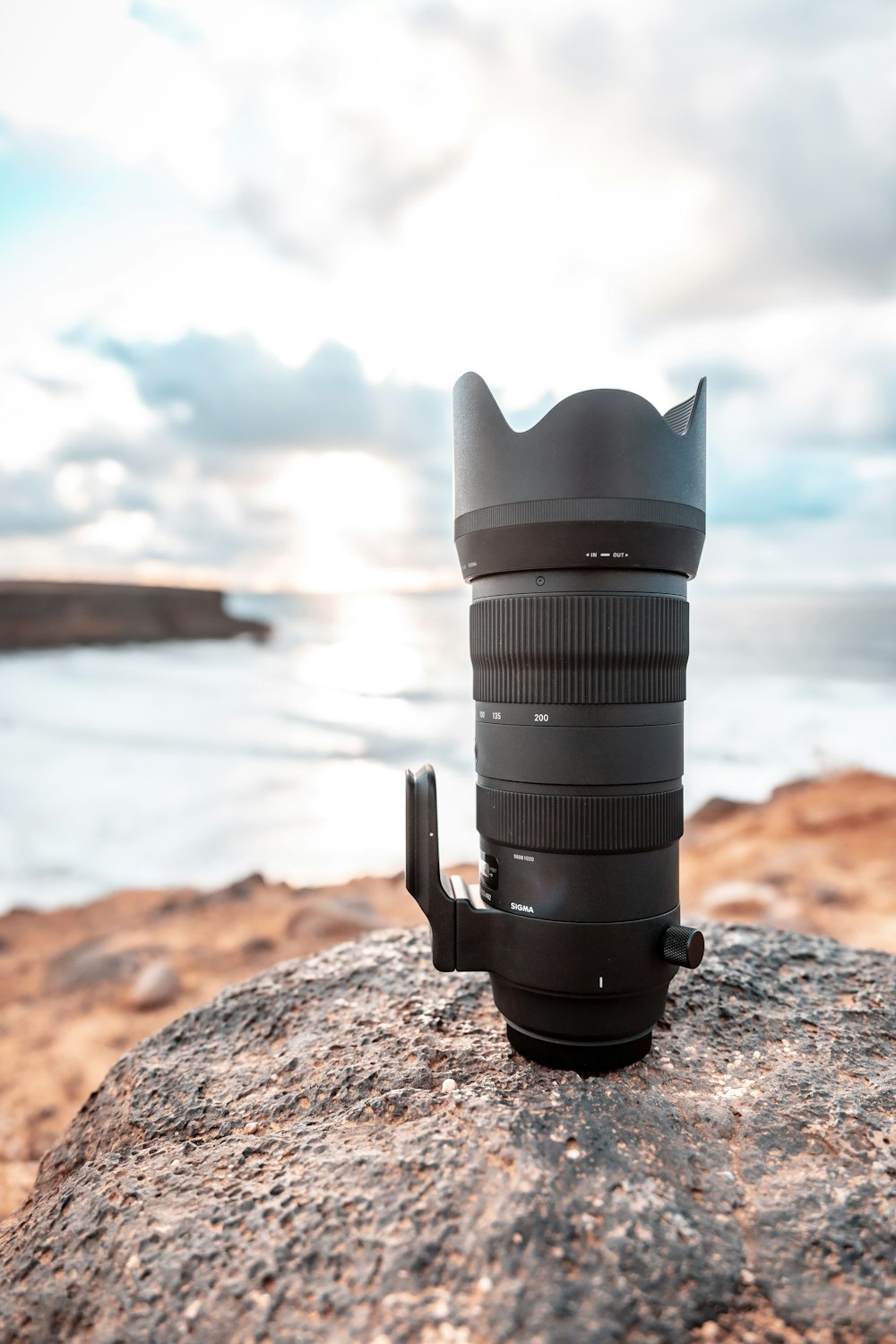 black dslr camera on brown rock near body of water during daytime