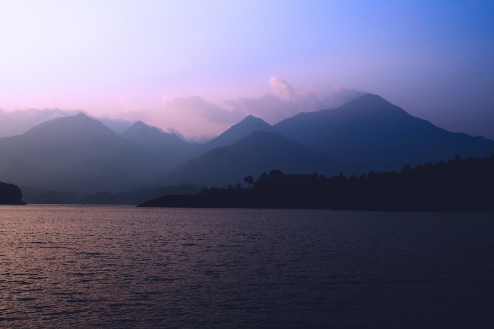 silhouette di montagne vicino allo specchio d'acqua durante il giorno