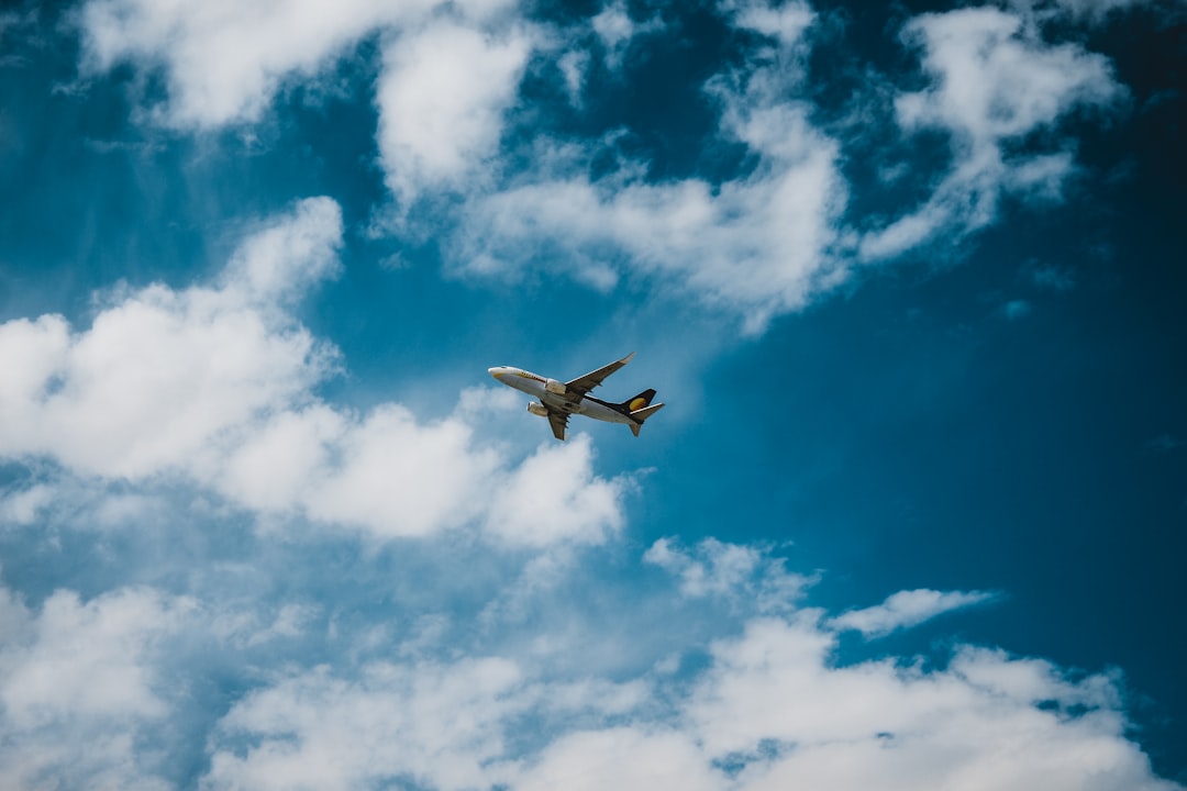 white airplane flying in the sky during daytime