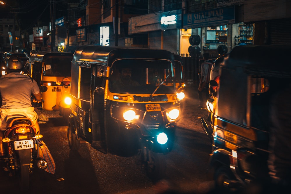 夜間の道路上の黒と黄色のオートリクシャー