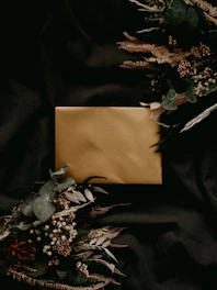 Close-up of luxurious printed obituary programs with gold foil accents on soft ivory paper.