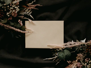A warm taupe square card with a delicate sunburst design in subtle gold.
