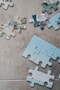 white jigsaw puzzle pieces on brown marble table