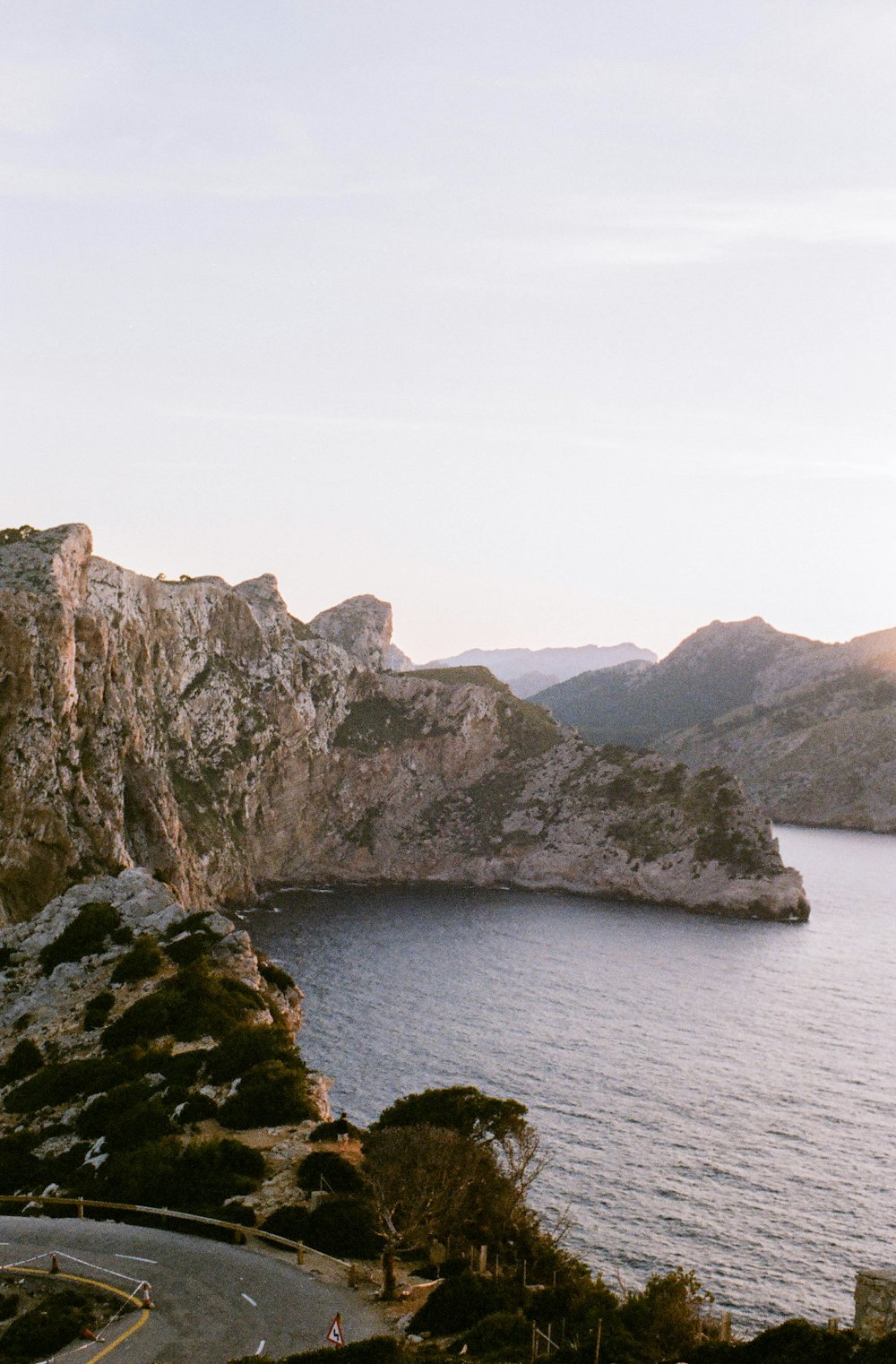 Montaña rocosa marrón y verde junto al cuerpo de agua durante el día