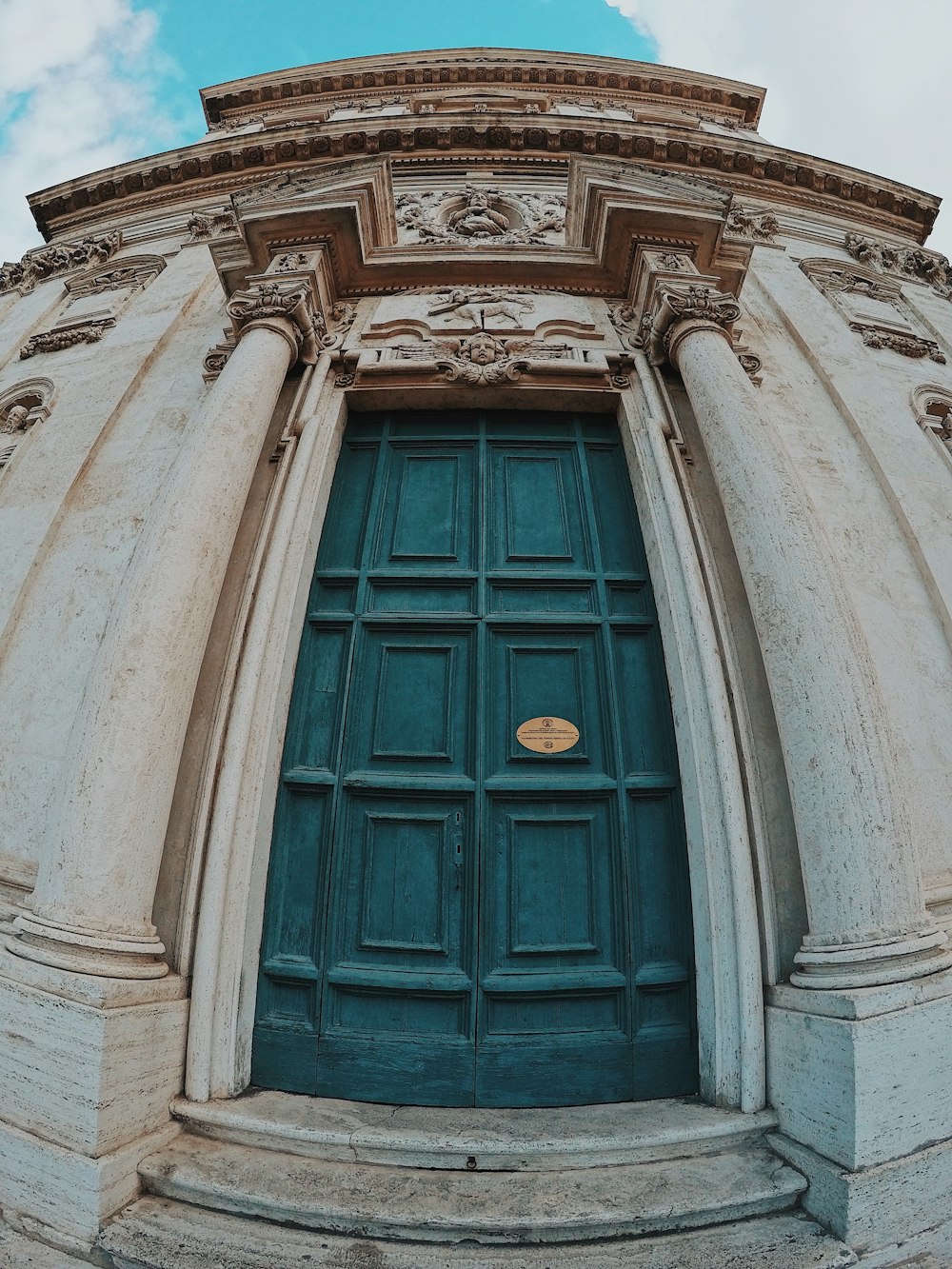 blue wooden door on white concrete building