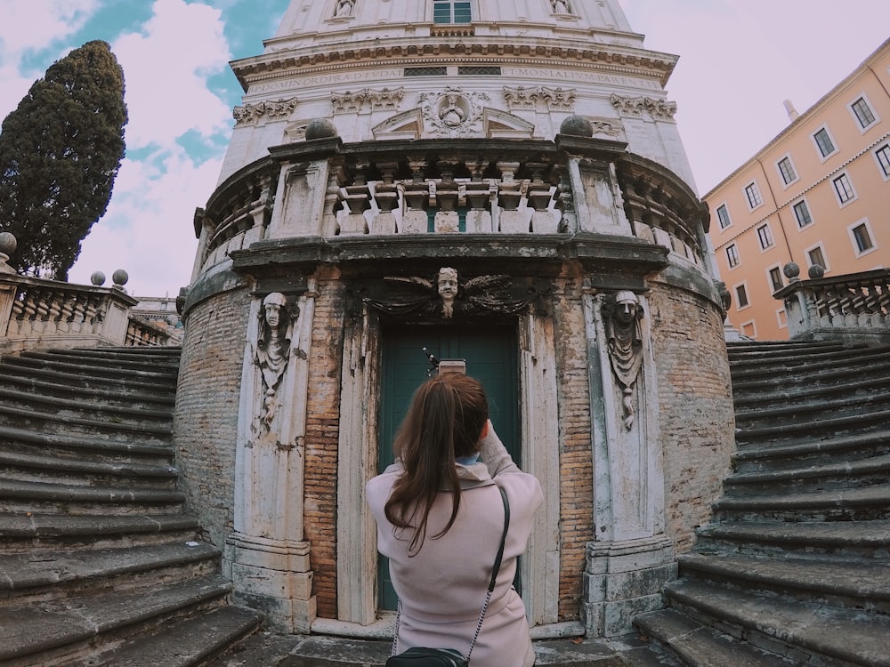 woman in white shirt standing on stairs during daytime