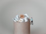 a miniature man standing on top of a pile of toilet paper