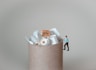 a miniature man standing on top of a pile of toilet paper