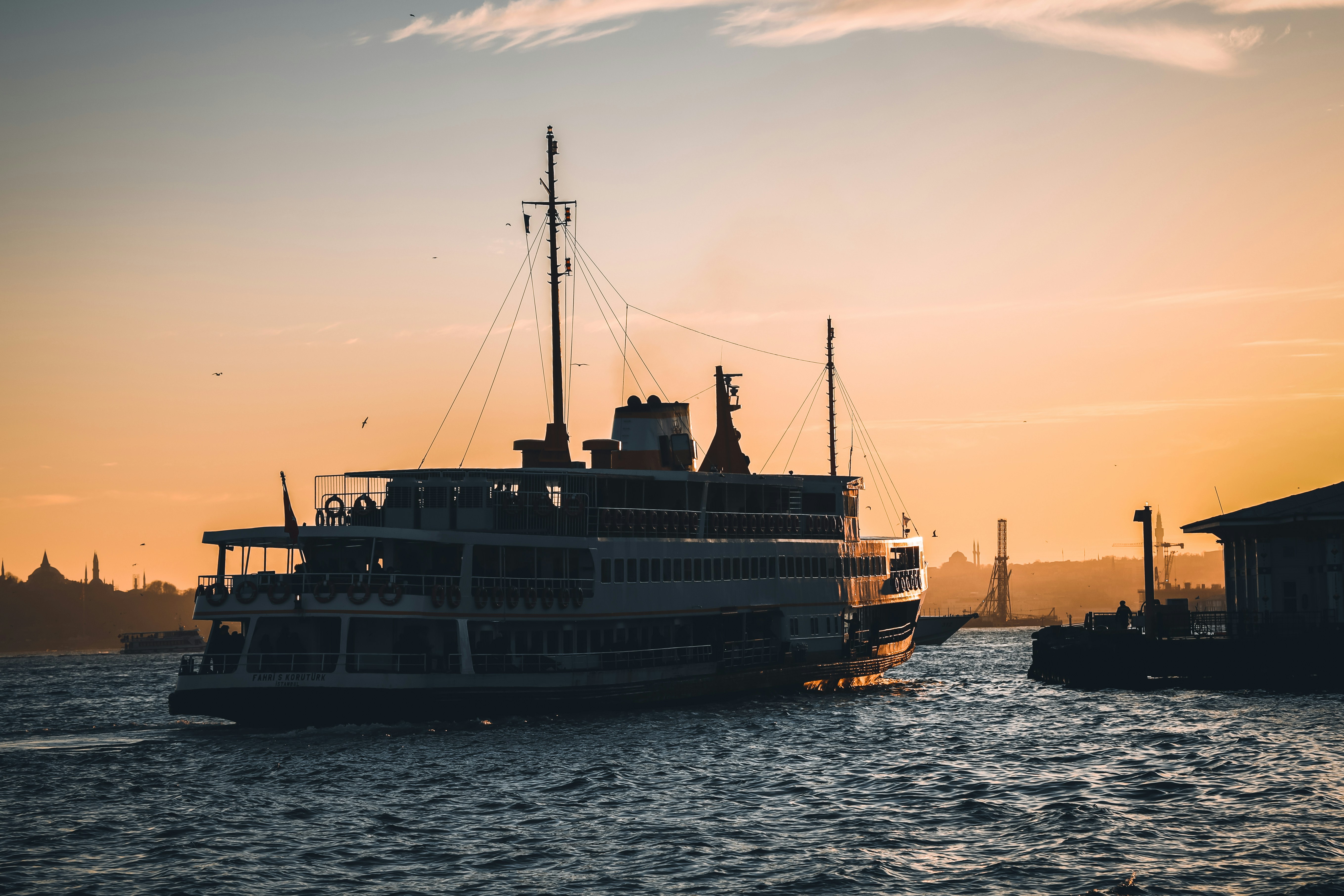 black and white ship on sea during sunset