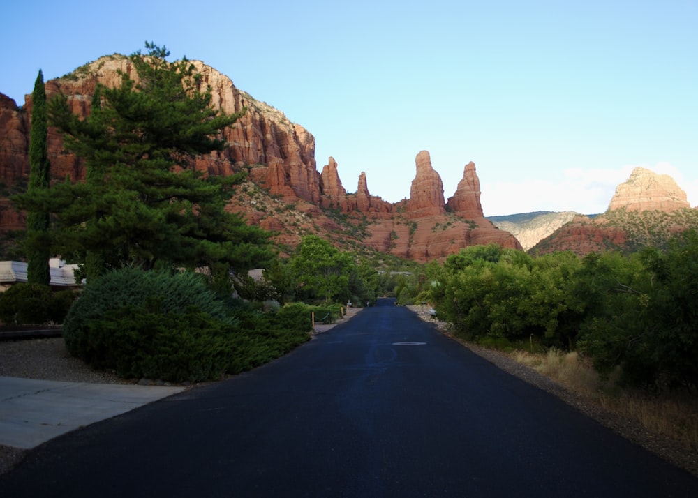 black asphalt road between brown rock formation during daytime
