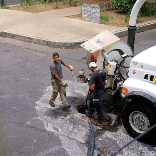 Technician using advanced equipment to unclog a kitchen drain in a residential home.