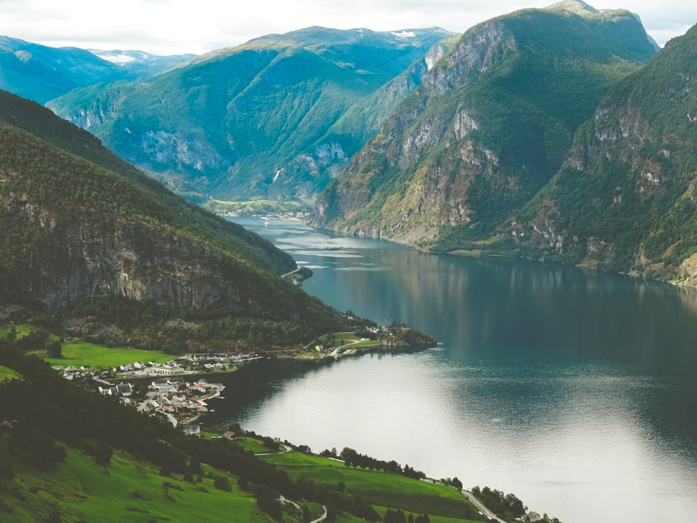 green and brown mountains beside lake during daytime