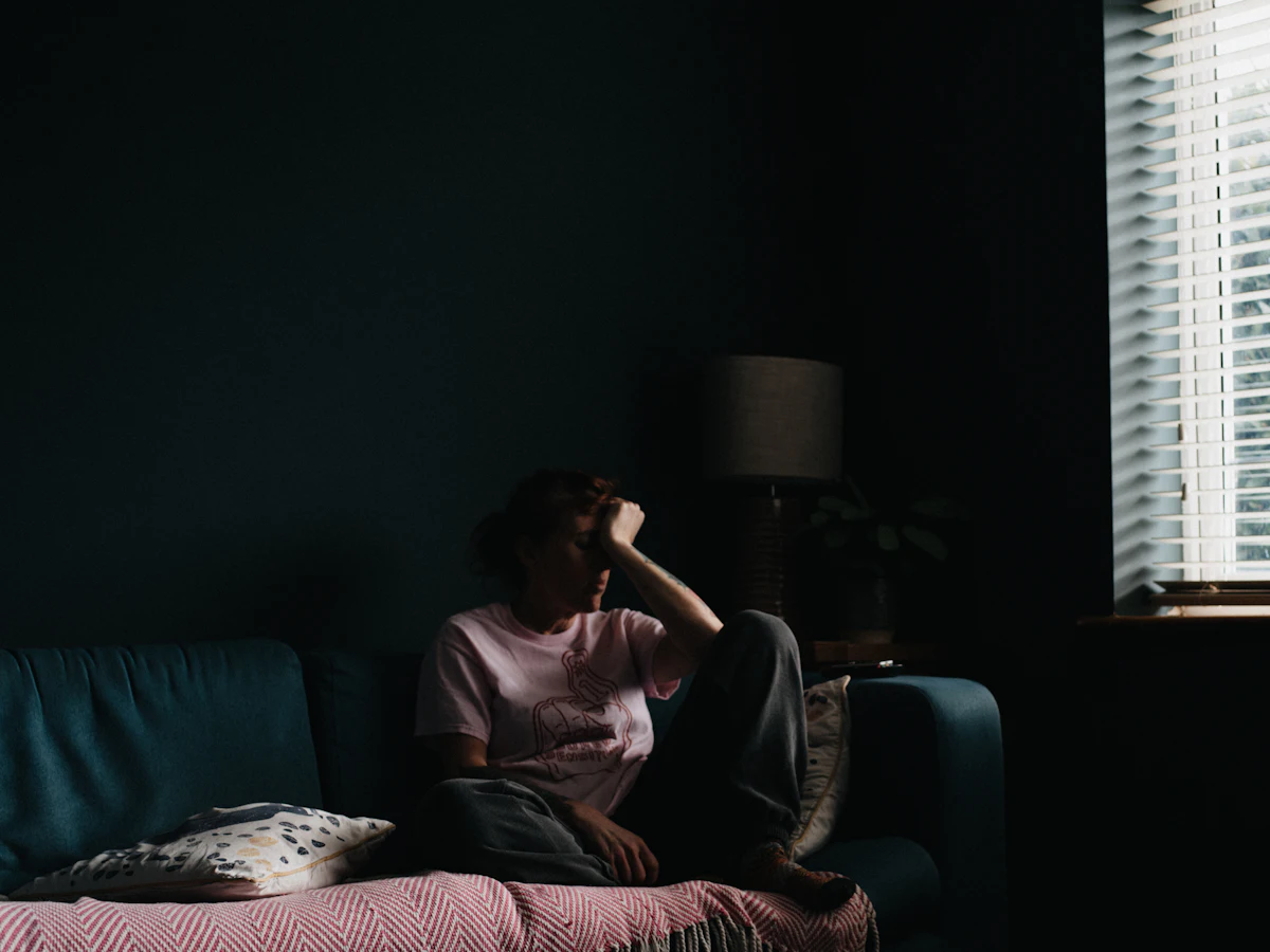Woman in her forties resting on a sofa during the day, a common experience during perimenopause