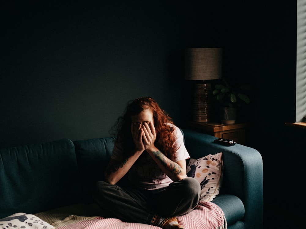 woman in black and white floral shirt sitting on black couch