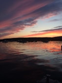 Colorful sky reflecting on the calm waters of Santa Barbara harbor at dusk.