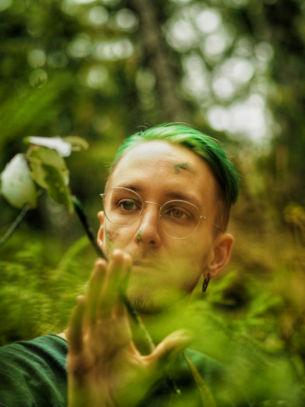 woman in green shirt with white flower on her ear