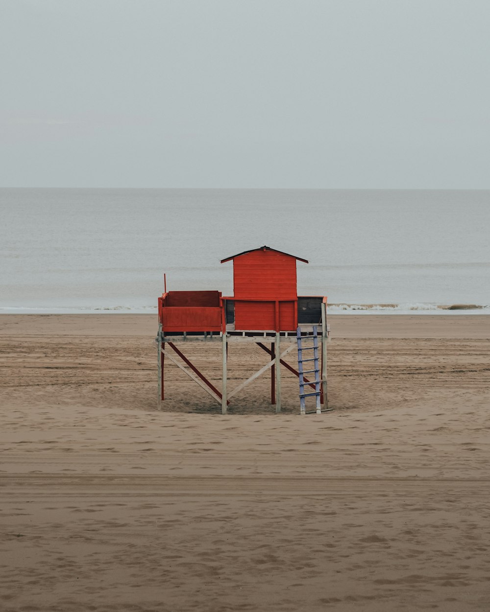 red wooden shed on beach shore during daytime