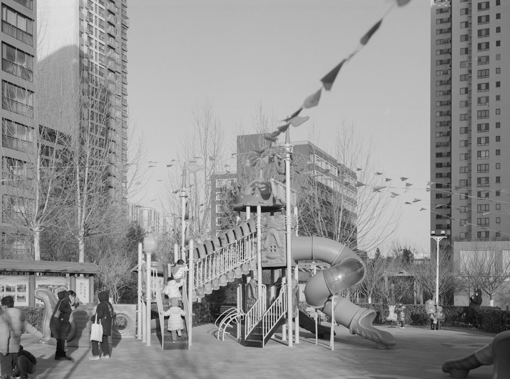 grayscale photo of people walking on street near buildings