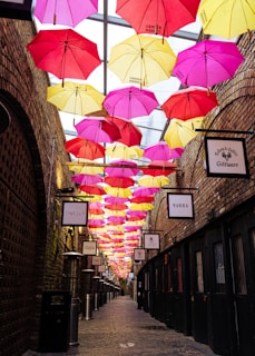 assorted umbrellas hanging on brown brick wall