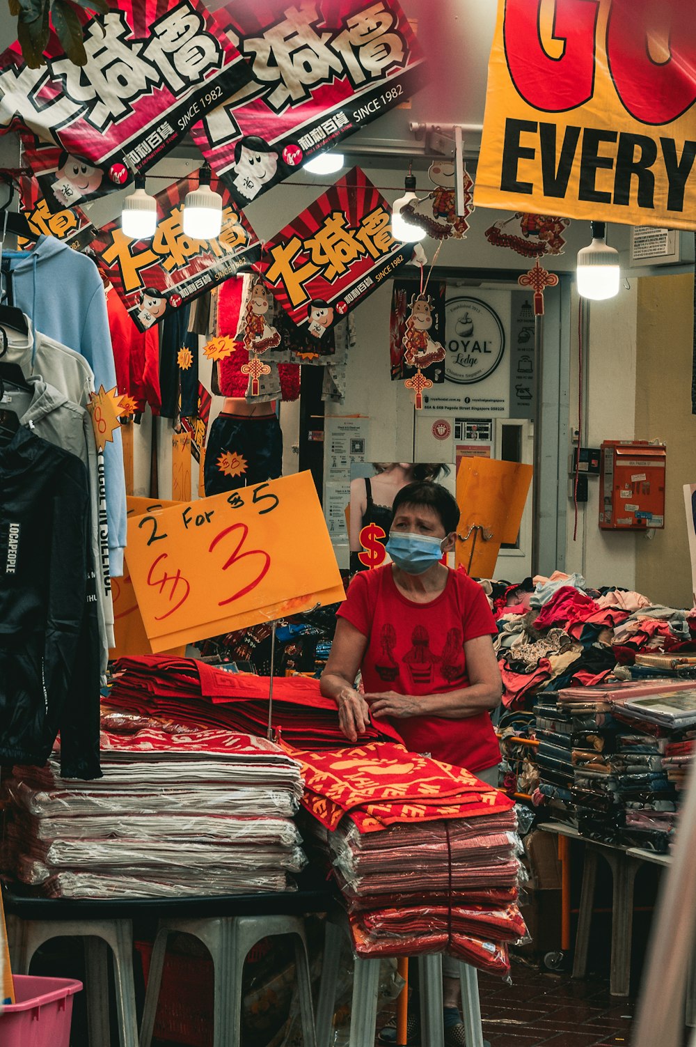 man in red crew neck t-shirt standing near clothes store