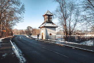 white and brown wooden house near bare trees under blue sky during daytime